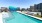 a pool with a large apartment building in the background