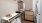 a closet with shelving, hanging clothes and stackable washer/dryer 