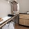 a closet with shelving, hanging clothes and stackable washer/dryer 