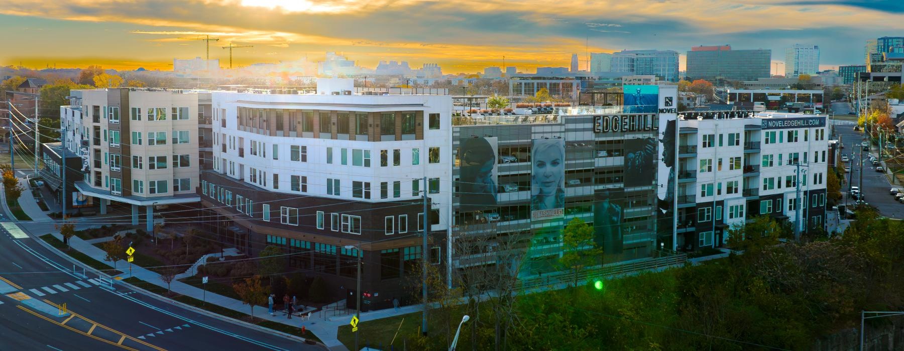 exterior drone shot of novel edgehill apartment building at sunset