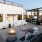 a patio with a fire pit and chairs