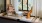a room with a window and a chair and a table with a lamp