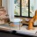 a room with a window and a chair and a table with a lamp