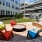 a deck with chairs and tables outside apartment building